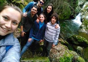 group of friends hiking next to a creek in Spain