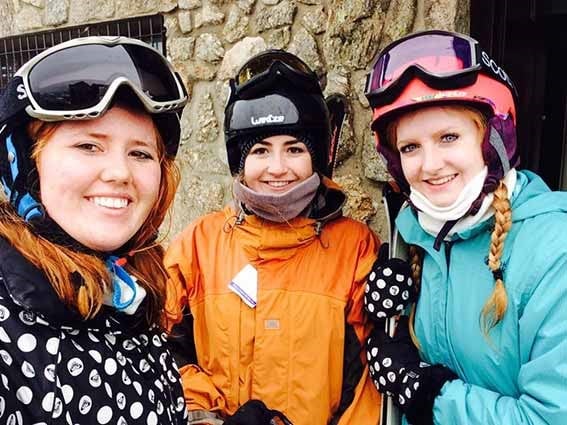 Three girls with skiing attire.